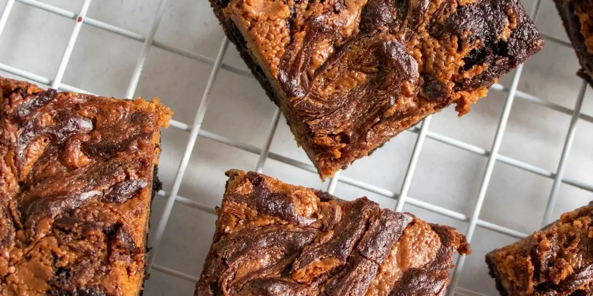 Brownies panggang yang sudah dipotong kotak-kotak di atas rak pendingin.